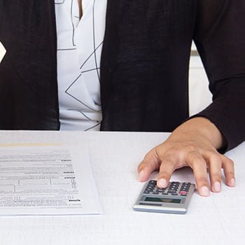 woman calculating numbers at desk